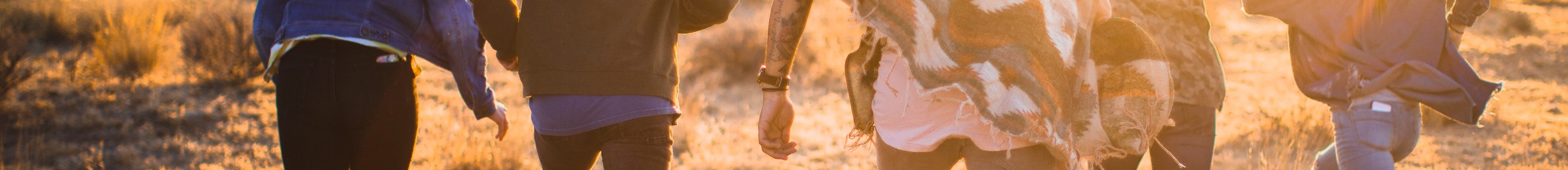 fiver person running on the field near trees